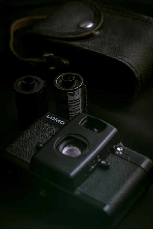 a close up of a camera on a table, inspired by Louis Faurer, unsplash, medium format. soft light, cameras lenses, dark photo, vhs colour photography