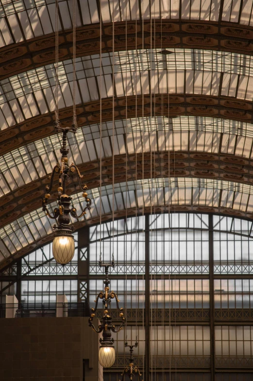 a train station with a bunch of lights hanging from the ceiling, inspired by Édouard Detaille, art nouveau, detail structure, victorian arcs of sand, demur, dramatic lighting - n 9