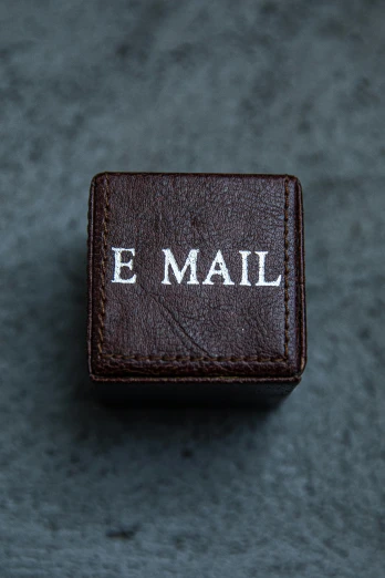 a small brown box with the word e mail written on it, by Eden Box, unsplash, letterism, leather, ring, pbr material, dan witz