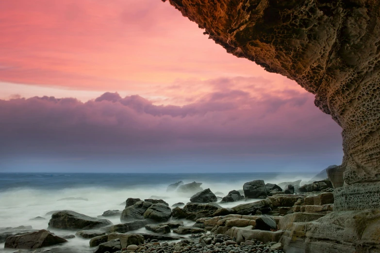 a view of the ocean from inside a cave, by Andrew Geddes, unsplash contest winner, romanticism, pink sky, ultrawide landscape, fine art print, dawn setting