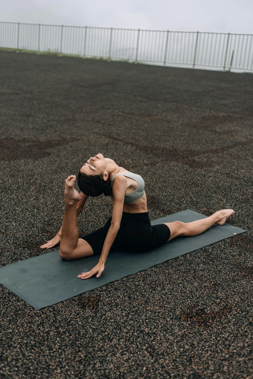 a woman doing a yoga pose on a mat, by Carey Morris, pexels contest winner, sporty physique, indonesia, serpentine pose gesture, square