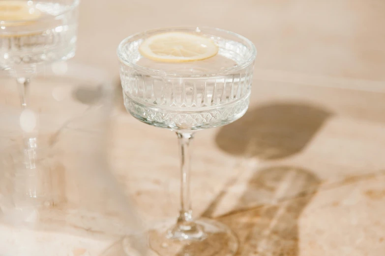 a couple of wine glasses sitting on top of a table, inspired by Ndoc Martini, unsplash, renaissance, with lemon skin texture, made of crystal, detail shot, white