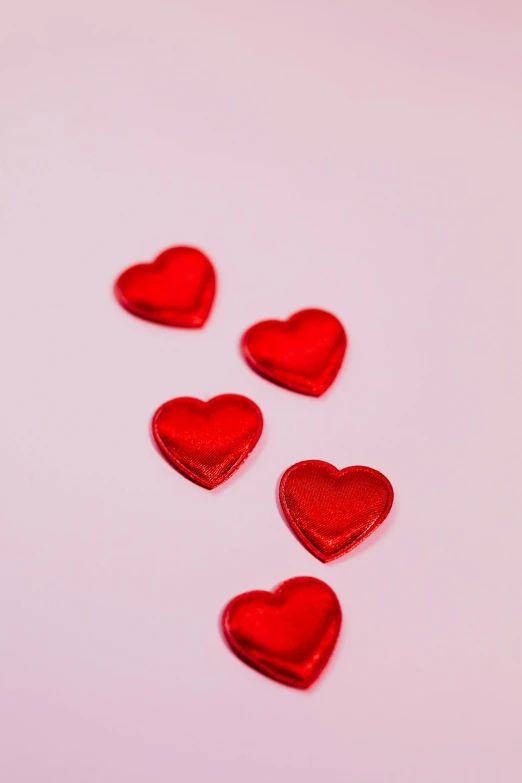 a group of red hearts sitting on top of a white surface