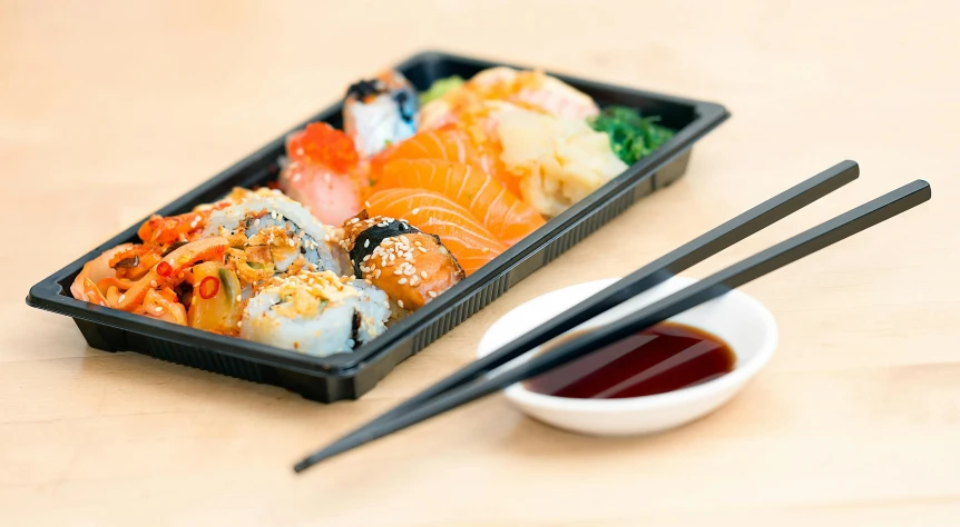 a tray of sushi with chopsticks next to it, by Julia Pishtar, unopened, komorebi, close together, rectangular