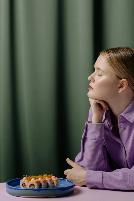 a woman sitting at a table with a plate of sushi, an album cover, inspired by Anna Füssli, trending on unsplash, hyperrealism, green and purple, portrait of elle fanning, contemplative, prominent jawline