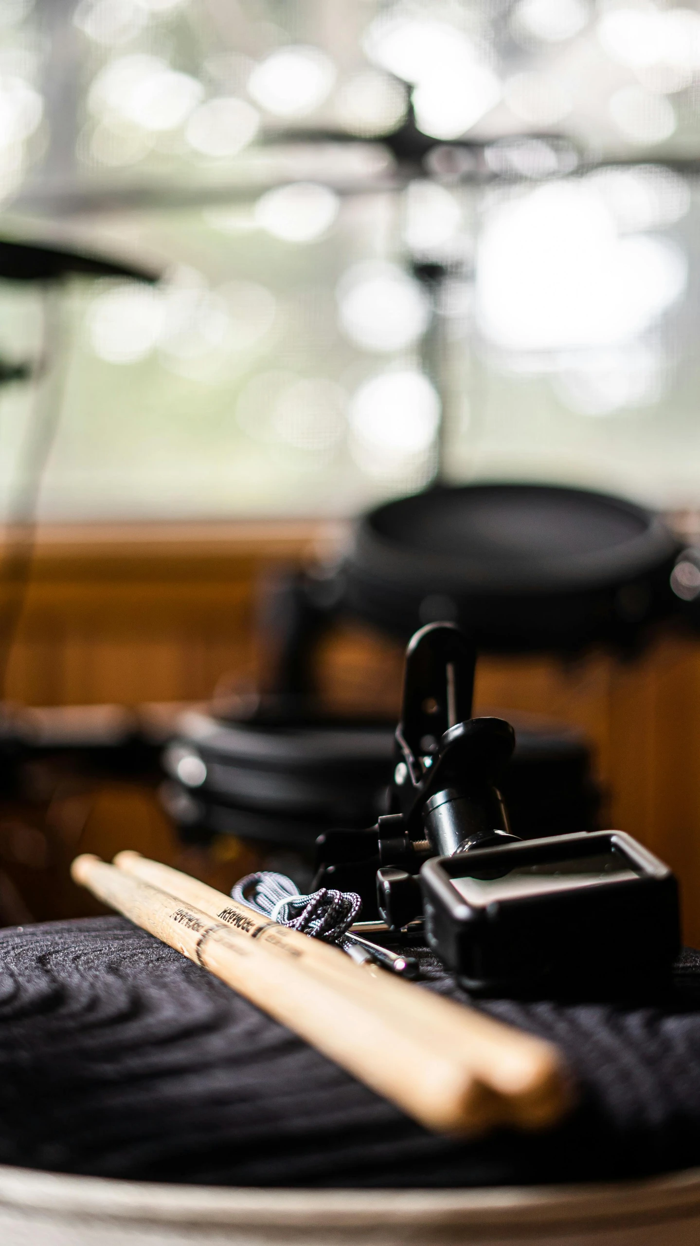 a drum kit sitting on top of a wooden table, on a wooden desk, close-up of a robot sitting down, high-quality photo, no cropping