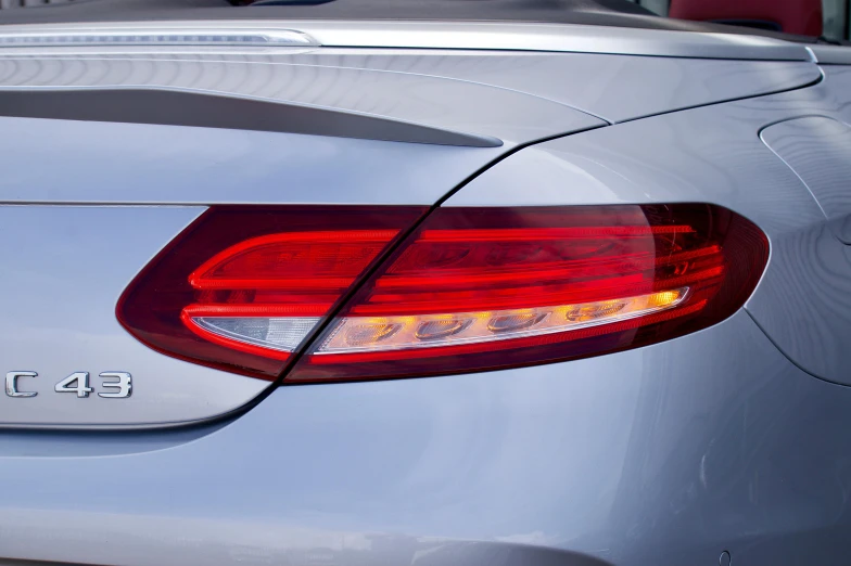 a close up of the tail lights of a car, by Julian Allen, pexels, convertible, pale blue backlight, mercedez benz, sleek visor