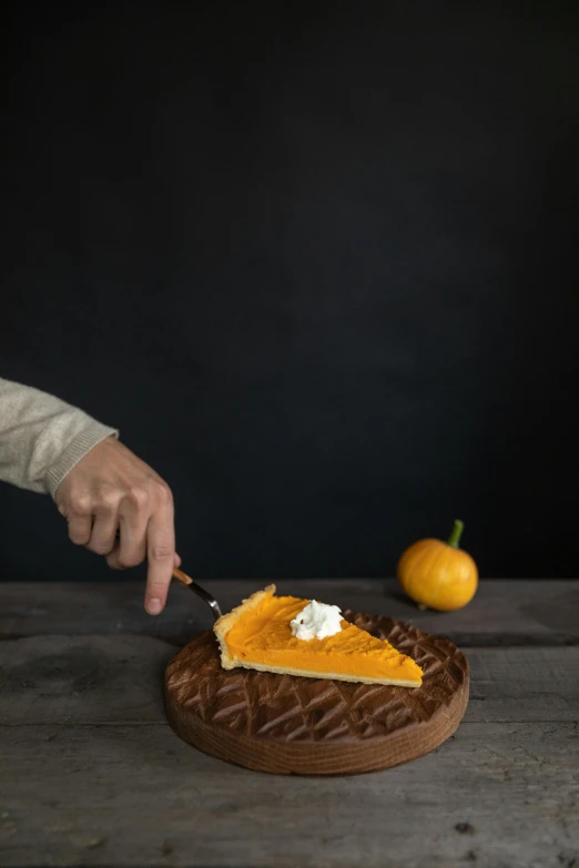 a person cutting a piece of pie with a knife, dark orange, pointè pose, shot with premium dslr camera, pumpkin