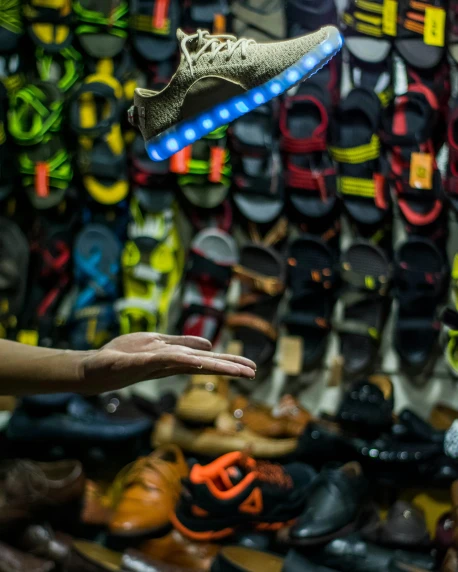 a person reaching for a shoe in front of a wall of shoes, colourful lighting, industries, inspect in inventory image, lgbtq