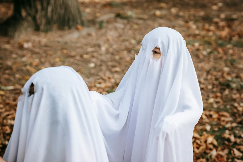 two women dressed in white standing next to each other, pexels contest winner, antipodeans, halloween ghost under a sheet, diverse costumes, blank, teenage girl