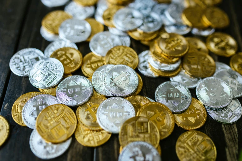 a pile of coins sitting on top of a wooden table, silver white and gold, edible crypto, thumbnail, background image