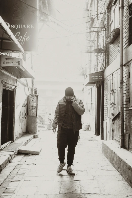 a man walking down a street talking on a cell phone, a black and white photo, inspired by Gang Hui-an, unsplash, standing in an alleyway, action bronson, :: morning, a very sad man