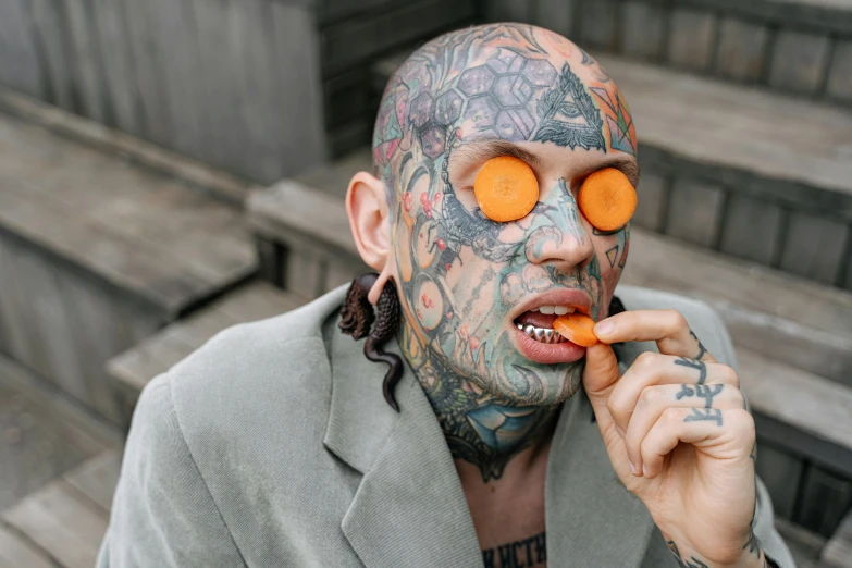 a man with a tattooed face eating carrots, pexels contest winner, eyepatches, snake man, ahegao, hairless