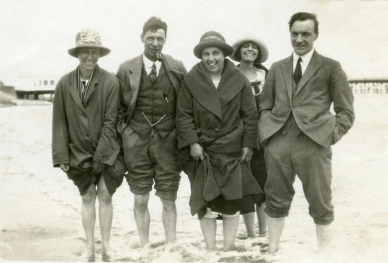 a group of people standing next to each other on a beach, by Elsie Henderson, wearing correct era clothes, panel, looking smart, people swimming