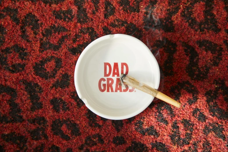 a white bowl sitting on top of a red carpet, inspired by Hendrik Gerritsz Pot, instagram, dada, smoking cigars, i'm dad, screen printed, dry grass