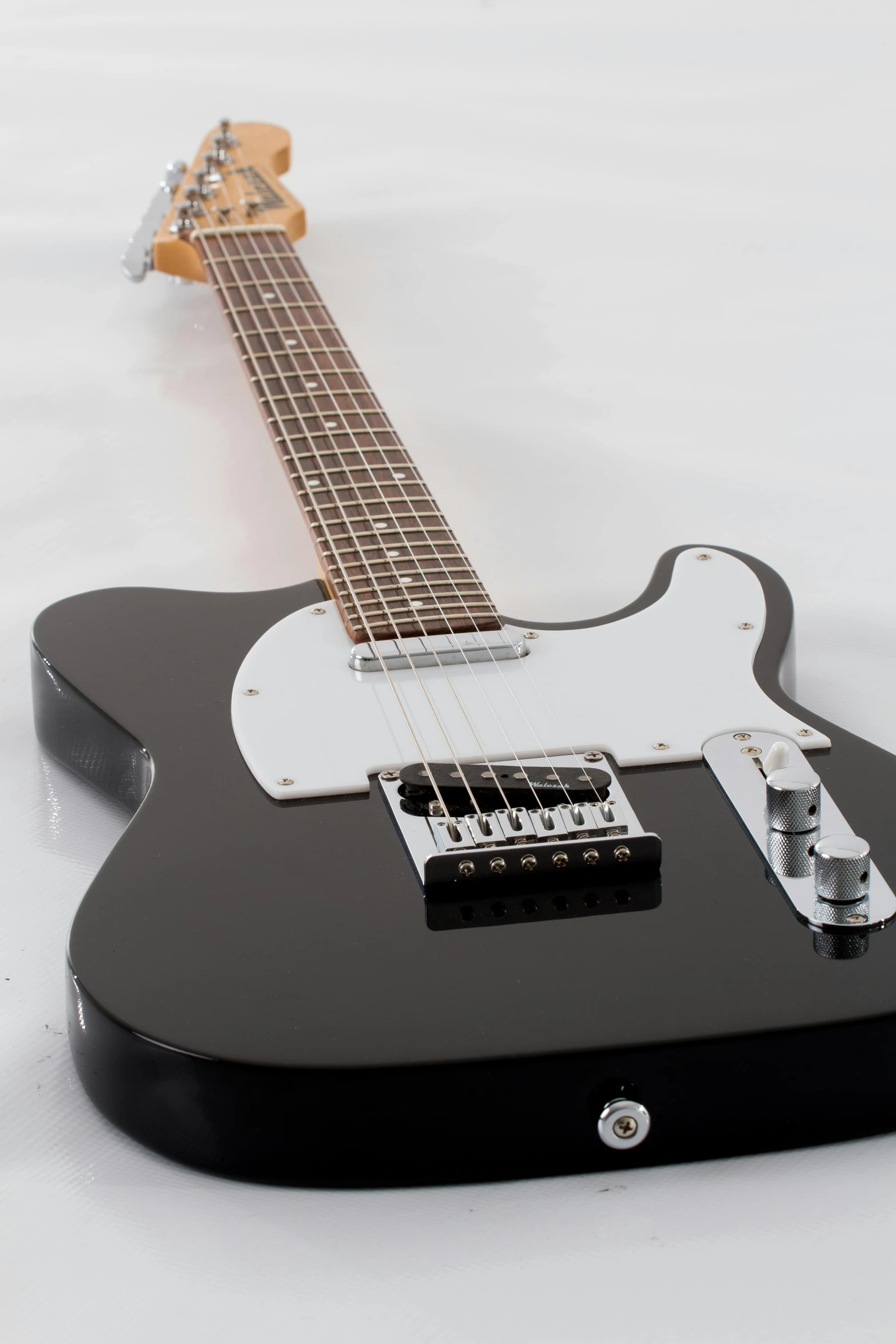 a black electric guitar on a white background, by Tom Bonson, pexels contest winner, promo image, rectangle, mini model, left trad