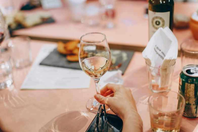 a person sitting at a table with a glass of wine, pexels contest winner, white wine bottle, leesha hannigan, back of hand on the table, guide