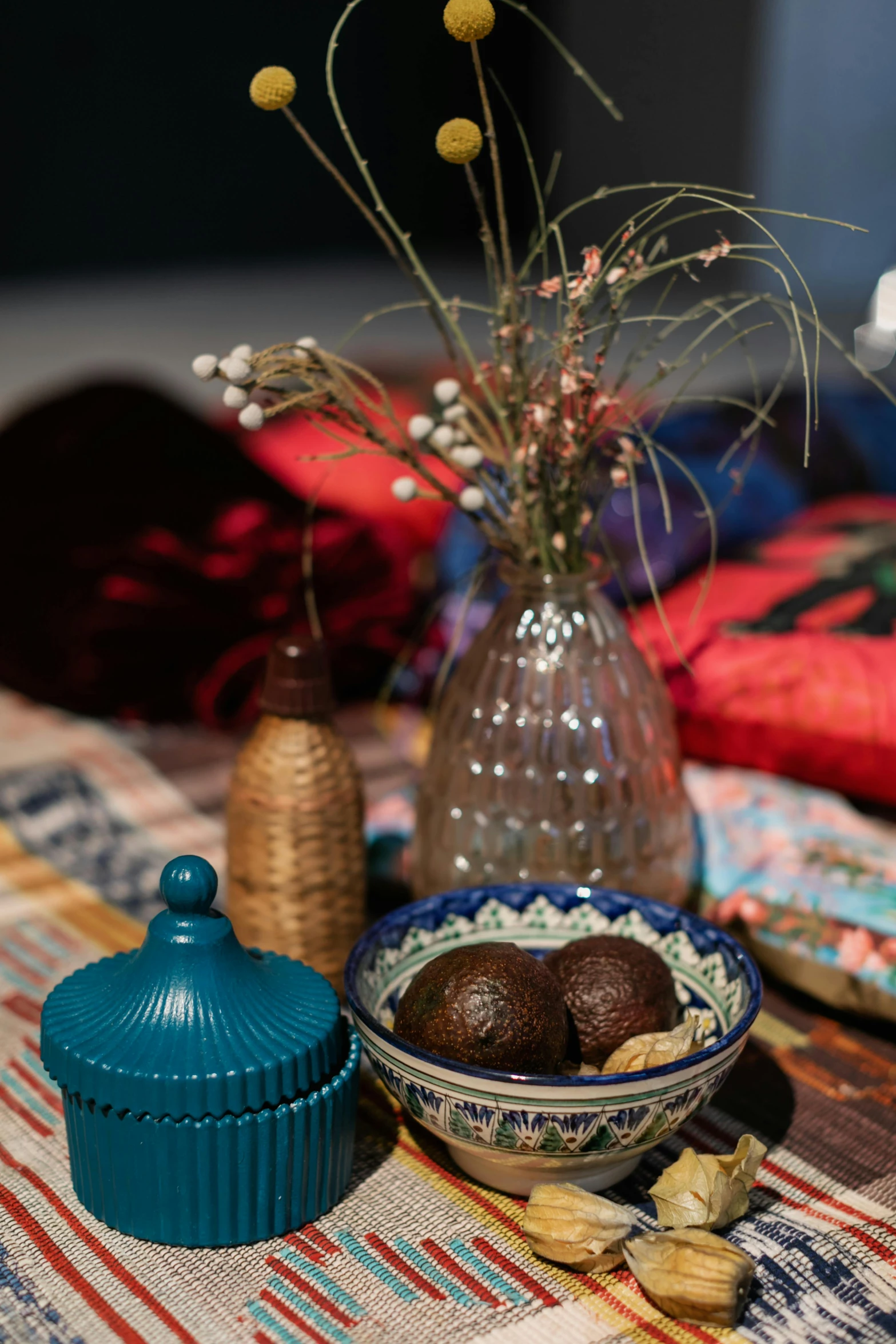 a table topped with bowls of food and a vase of flowers, a still life, inspired by Riad Beyrouti, unsplash, dau-al-set, brown red blue, candy decorations, interior of a tent, detailed product image