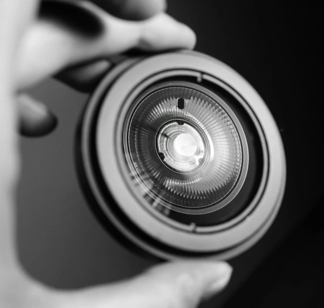 a close up of a person holding a camera, a black and white photo, by Mathias Kollros, pixabay, symmetrical rim light, lighting her with a rim light, macro lens product photo, uploaded