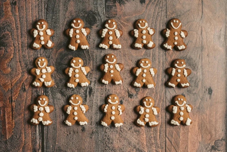 a group of gingerbreads sitting on top of a wooden table, a portrait, pexels, 🦩🪐🐞👩🏻🦳, listing image, in a row, many legs