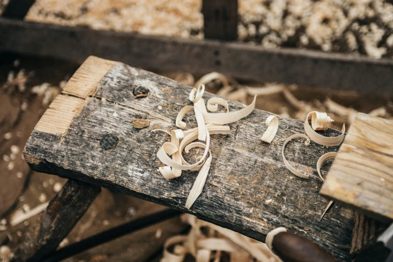 a pair of scissors sitting on top of a piece of wood, a woodcut, trending on pexels, wooden bowl, ash thorp, ribbon, wooden buildings