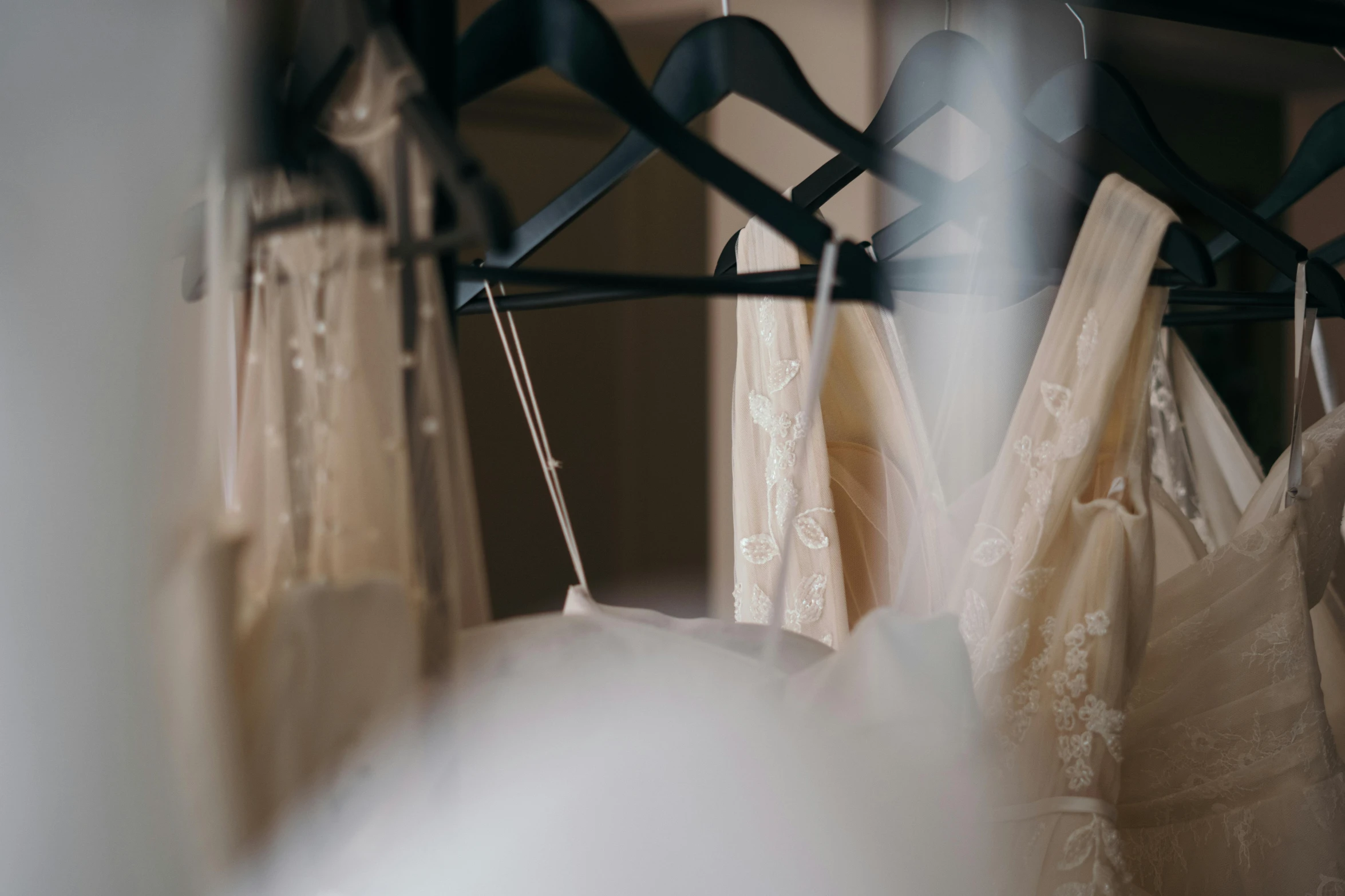 a row of wedding dresses hanging on a rack, inspired by Elsa Bleda, trending on unsplash, blurred, fan favorite, lingeries beauty, off - white collection