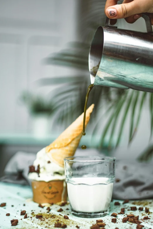 a person pouring coffee into a cup on a table, a still life, unsplash, ice cream cone, thumbnail, stainless steal, cooking oil