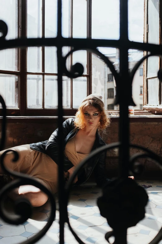 a woman laying on the ground in front of a window, a picture, inspired by Elsa Bleda, pexels contest winner, renaissance, standing astride a gate, a redheaded young woman, in a warehouse, in style of valentin serov