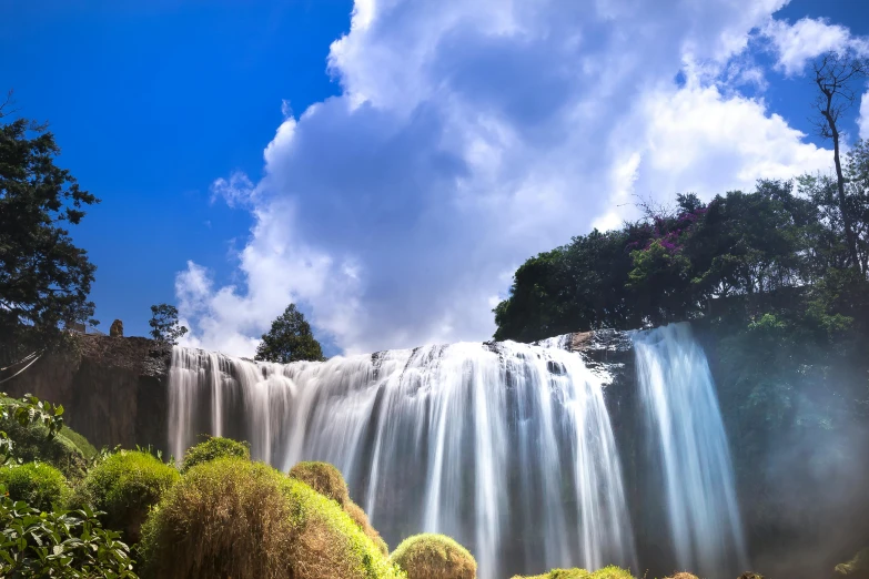 a waterfall in the middle of a lush green forest, by Reuben Tam, pexels contest winner, hurufiyya, blue sky, panoramic shot, hou china, avatar image