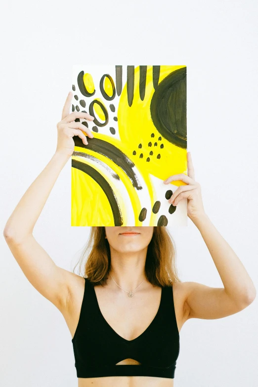 a woman covering her face with a piece of paper, a minimalist painting, trending on pexels, abstract art, yellow and black, wearing yellow croptop, 144x144 canvas, on white background