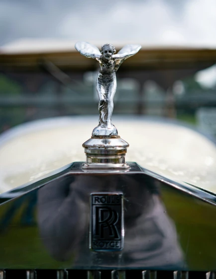 a close up of a hood ornament on a car, by Rupert Shephard, unsplash, renaissance, square, celebration, 1920s picture, wearing robes of silver