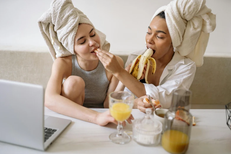 a woman sitting next to a little girl eating a banana, trending on pexels, renaissance, wearing a towel, couple on bed, manuka, teenager hangout spot