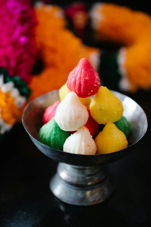 a bowl filled with colorful candy sitting on top of a table, hindu ornaments, san francisco, jasmine, cone shaped