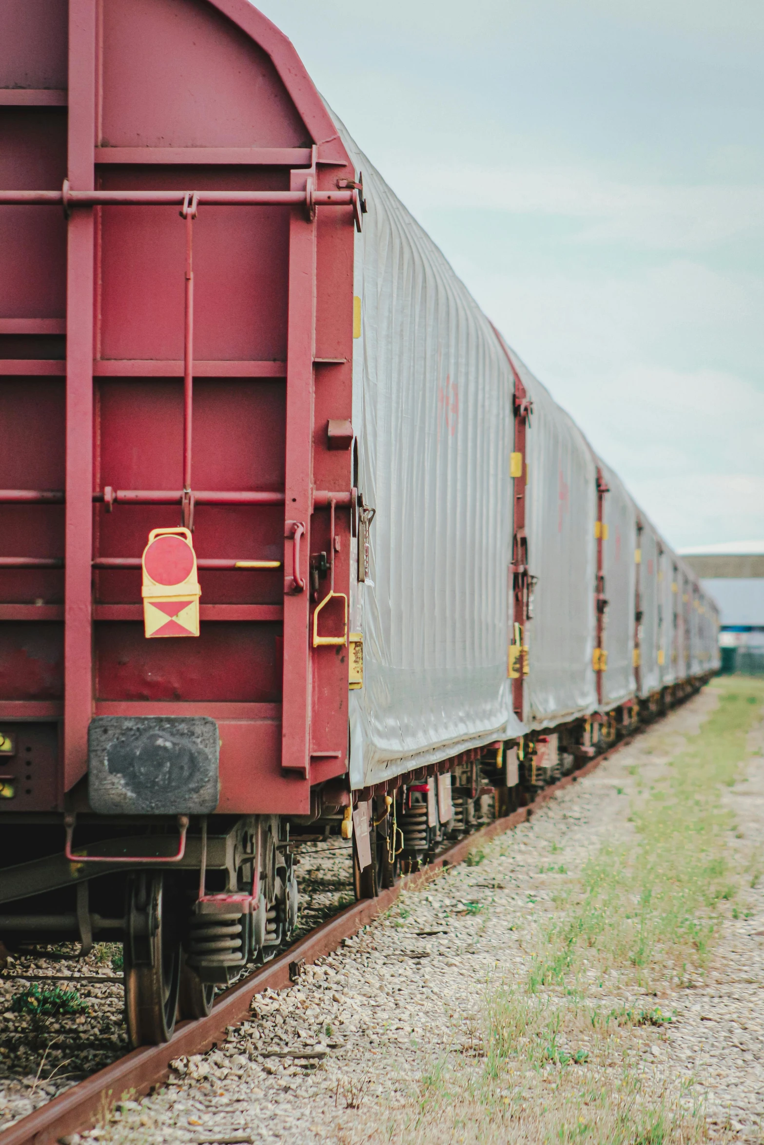 a train traveling down train tracks next to a field, trading depots, maroon, full width, lightweight