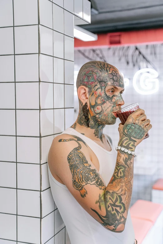 a man with tattoos drinking from a cup, trending on pexels, scaly skin, 1990's diner full of zombies, gay, blank stare”