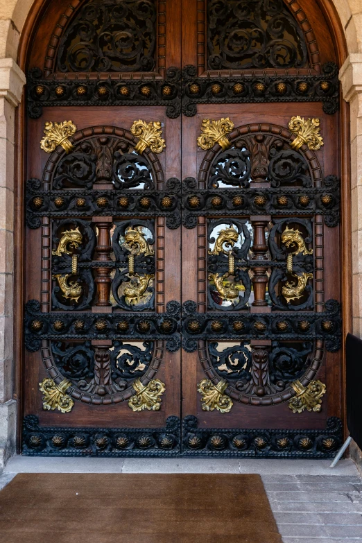 a person sitting on a bench in front of a large wooden door, inspired by Christopher Wren, baroque, hyperdetailed metalwork, close - up of the faces, large gate, gold and black metal