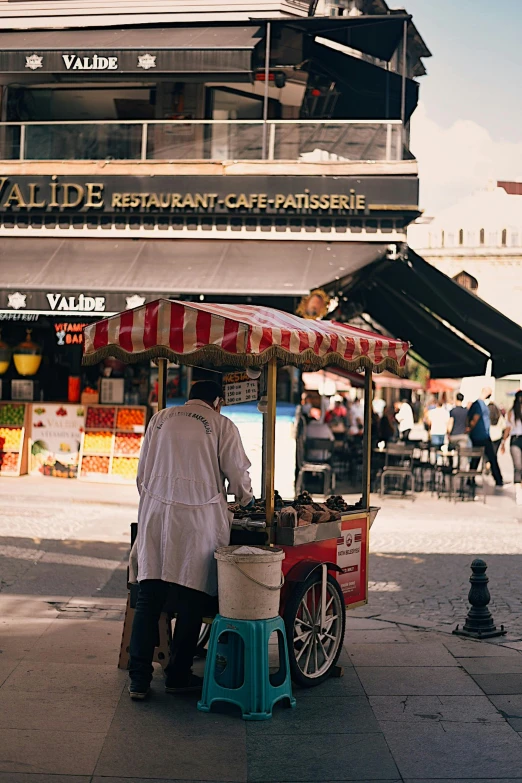 a man selling food from a cart on a city street, by Julia Pishtar, trending on unsplash, inside a french cafe, square, awnings, mall