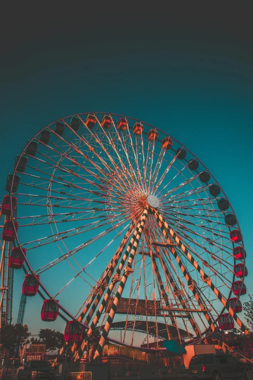 a ferris wheel in front of a blue sky, in the evening, profile image