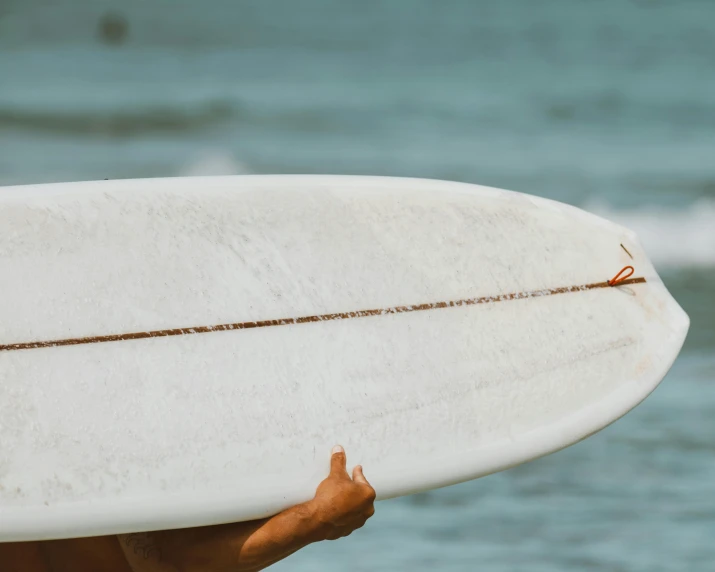 a man holding a white surfboard on top of a beach, pexels contest winner, zoomed in, 🦩🪐🐞👩🏻🦳, rounded corners, nanae kawahara
