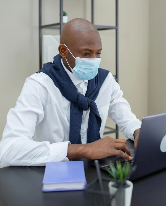 a man wearing a face mask working on a laptop, clean medical environment, george pemba, grey, thumbnail