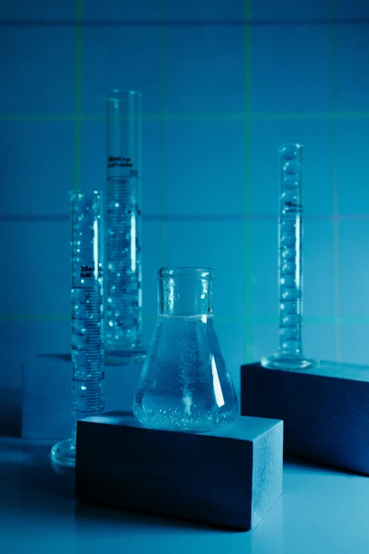 a couple of glass vases sitting on top of a counter, by Anna Haifisch, analytical art, molecules, crystal column, underground lab, promo image