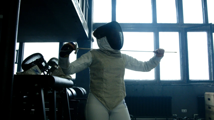 a fencer standing in front of a window holding a sword, lynn skordal, with wires and bandages, from the distance, photograph of a techwear woman