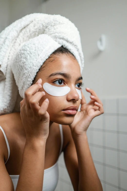 a woman putting eye patches on her face, by Julia Pishtar, trending on pexels, essence, teenage girl, spa, square