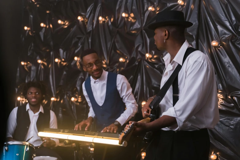 a group of men standing next to each other on a stage, an album cover, pexels, happening, 3 jazz musicians, melanchonic soft light, performing a music video, shot with sony alpha 1 camera