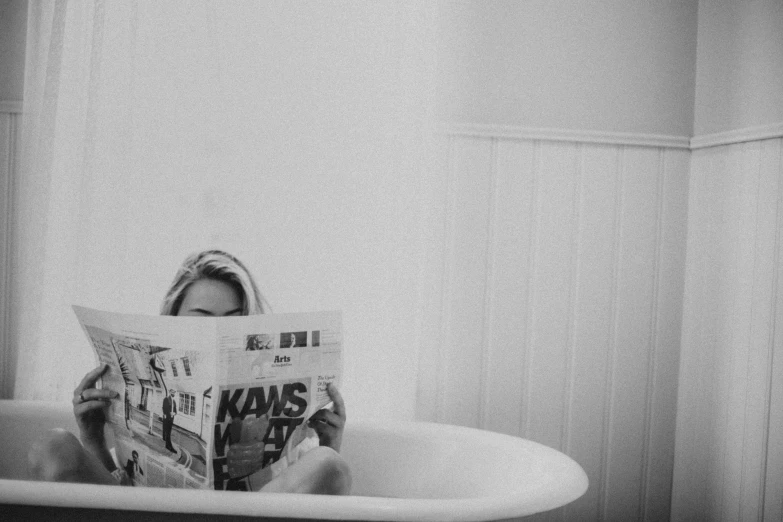 a woman sitting in a bathtub reading a newspaper, a black and white photo, by Karl Buesgen, pexels, gif, katey truhn, self - portrait!!!!