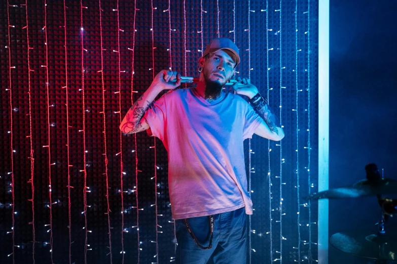 a man that is standing in front of a microphone, a portrait, pexels contest winner, graffiti, neon background lighting, mac miller, thumbnail, behind the scenes photo