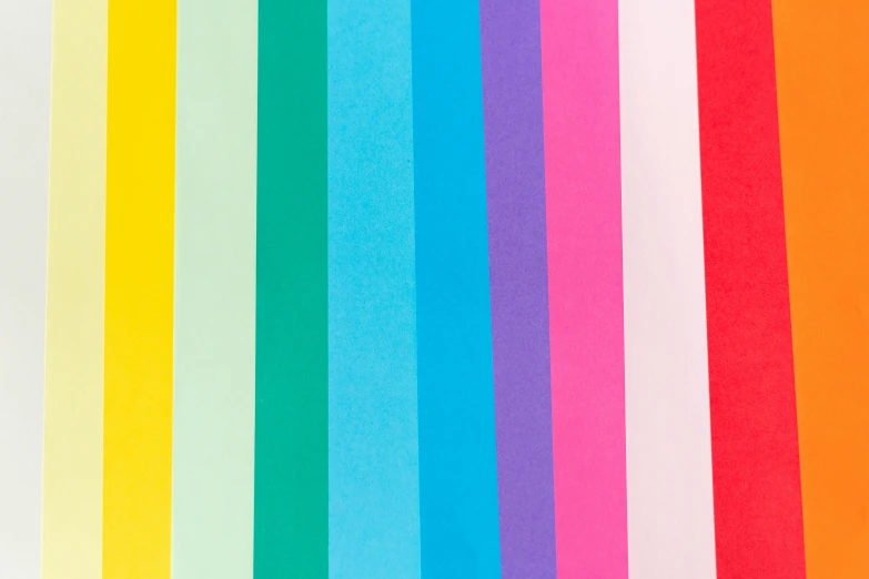 a bunch of different colored papers on a table, rainbow stripe background, detailed product image, full dynamic colour, 100lb cardstock