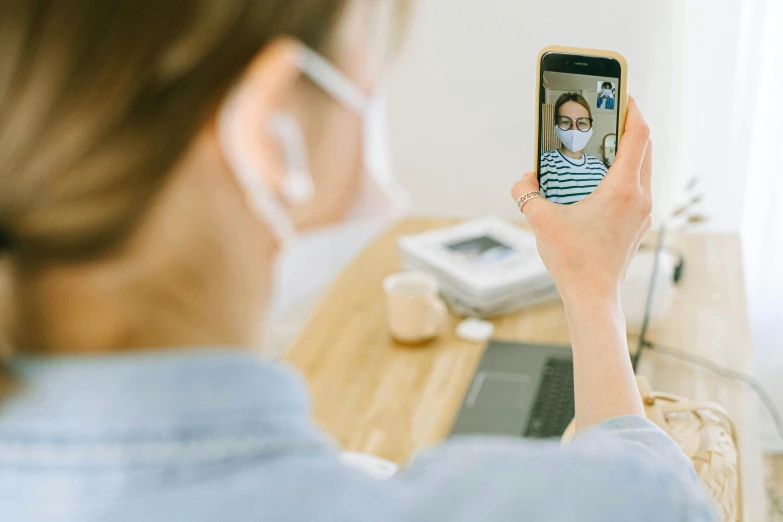 a woman taking a picture of herself on her cell phone, pexels, healthcare worker, avatar image, rectangle, masked person in corner