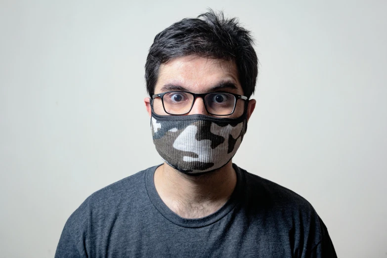 a close up of a person wearing a face mask, reddit, camo, reza afshar, nerdy appearance, grey