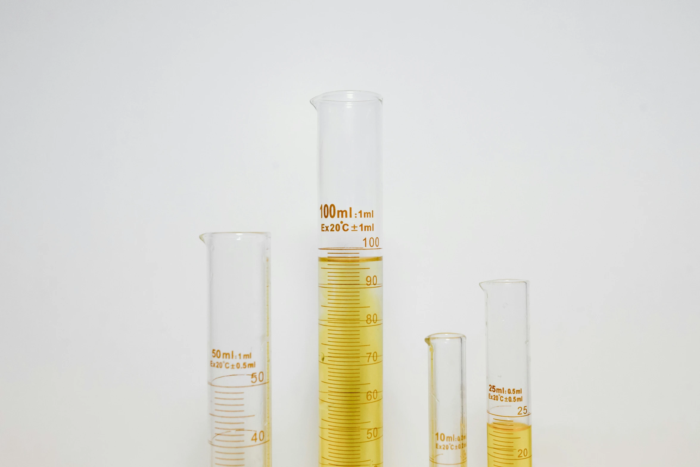 a group of test tubes sitting next to each other, an album cover, unsplash, yellow, glass labware, tall thin, huge gargantuan scale